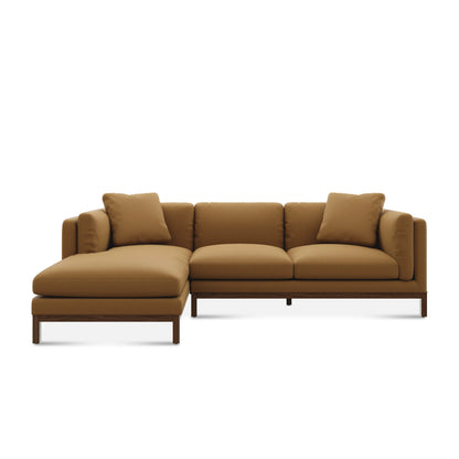 The Owen Chaise Sectional Sofa is a modern brown piece with plush cushions and a left-side chaise lounge, showcasing a minimalist style with clean lines and a sturdy wooden frame.