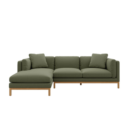 The Owen Chaise Sectional Sofa is a green L-shaped piece with a wooden base. It includes three seat cushions, a left-side chaise, and three loose back cushions, all presented in a modern and minimalist design.