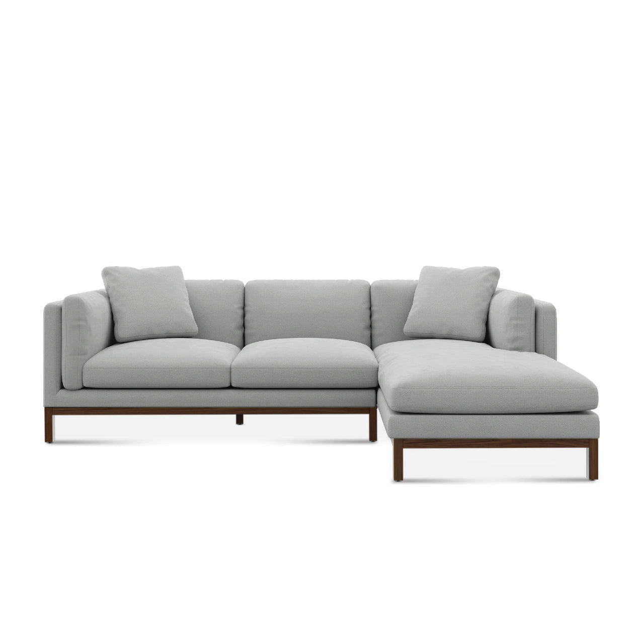 The Owen Chaise Sectional Sofa showcases a contemporary L-shaped design with light gray upholstery and low, squared cushions. It features clean lines and a wooden base, complemented by two back cushions for each seating area.