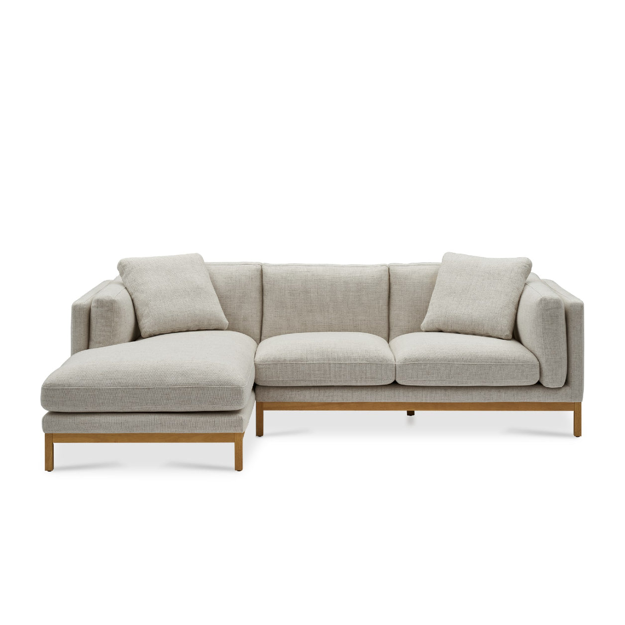 The Owen Chaise Sectional Sofa is a modern piece in beige, featuring a chaise lounge on the left side. It boasts a light-colored fabric with a minimalistic design, complemented by wooden legs and two matching throw pillows.