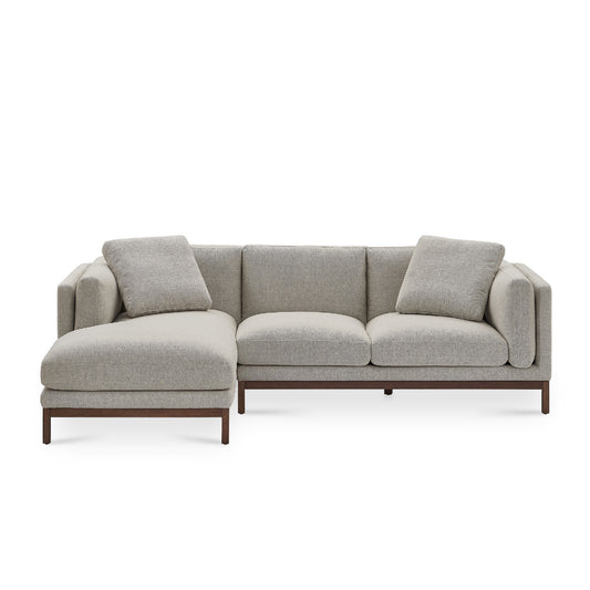 The Owen Chaise Sectional Sofa is a contemporary L-shaped design, featuring gray fabric upholstery and wooden legs. It offers plush seat and back cushions along with two matching throw pillows, providing both elegance and comfort.