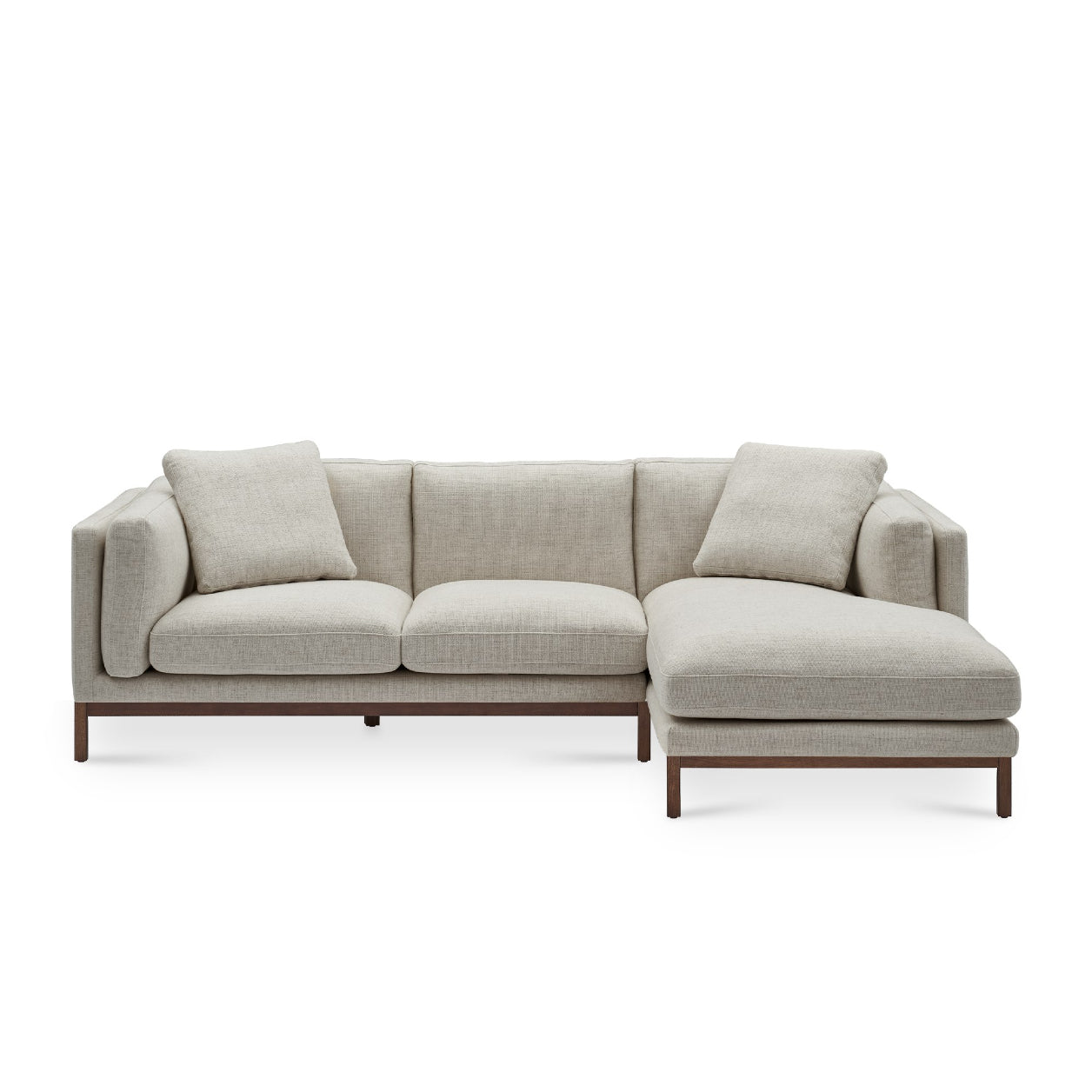 Introducing the Owen Chaise Sectional Sofa: a minimalist, light gray L-shaped sofa with three seat cushions and a chaise lounge on the right side. It showcases slender wooden legs and comes with two coordinating throw pillows.