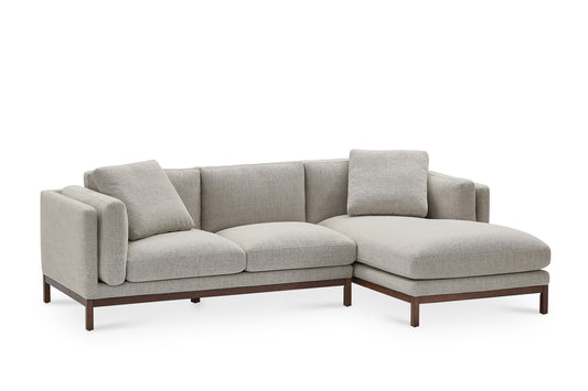 Introducing the Owen Chaise Sectional Sofa: a modern, light gray L-shaped sectional with plush cushions. It features a stylish wooden base and a left-facing chaise for ample seating space, complete with two matching pillows for added comfort.