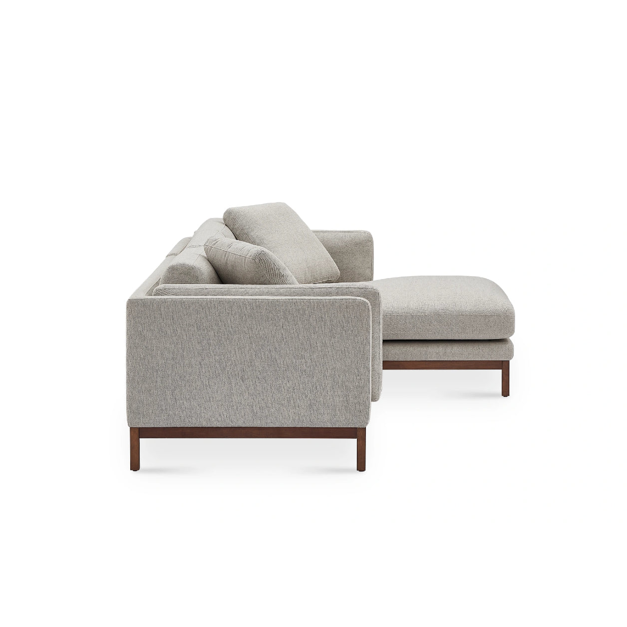 View from the side of the Owen Chaise Sectional Sofa featuring light gray upholstery and a wooden base. This modern sofa comes with plush cushions and includes a right-side chaise lounge. The minimalist design is showcased against a white background.