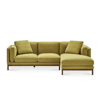 Introducing the Owen Chaise Sectional Sofa, a contemporary L-shaped sofa in an elegant olive green. It features three seat cushions and a chaise lounge on the right side, complemented by three matching back cushions. The sofa is supported by a wooden frame with sleek cylindrical legs.