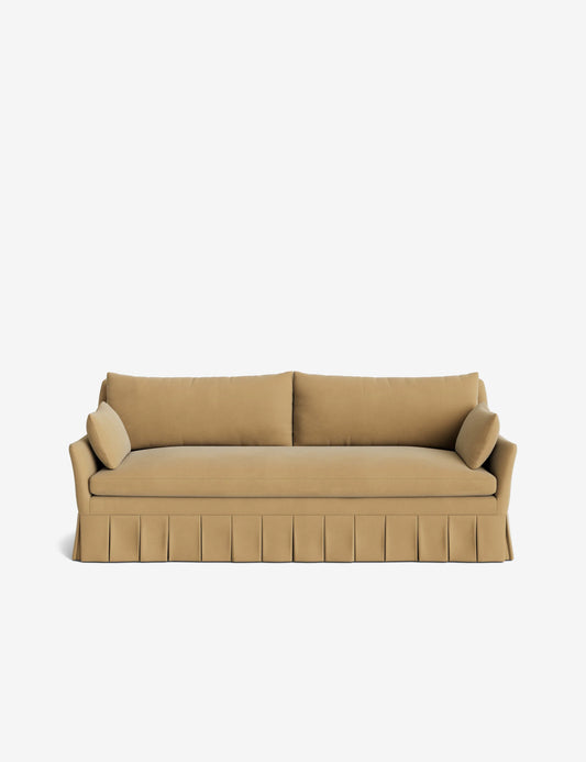 A Portola Pleated Sofa in beige, featuring a three-seater design with a pleated skirt and two cylindrical cushions, set against a plain white background.