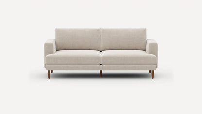 Introducing the Ember Mid-Century Modern 75" Sofa— a contemporary light beige piece showcasing clean lines and a minimalist design. This sofa features two seat cushions and two back cushions, complemented by low armrests and wooden legs, all set against a plain white background.