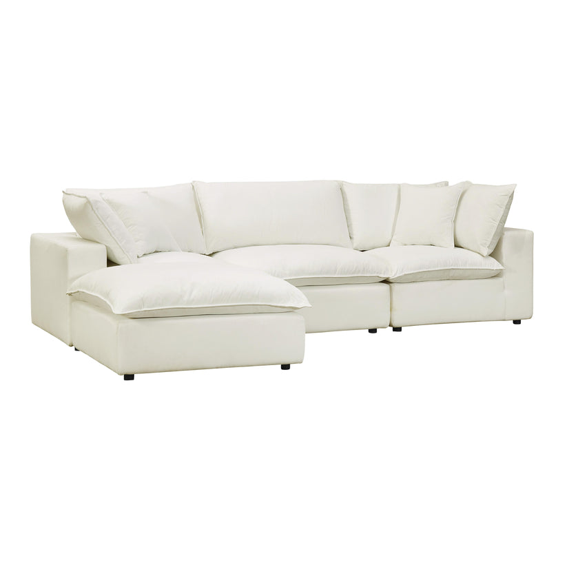 The Cali Performance Fabric Modular 4 Piece Sectional is a spacious, cream-colored sofa with plush cushions and a deep seat. Its design includes a chaise lounge on one end, forming an L-shaped configuration. The sofa features clean, modern lines and rests on small, unobtrusive legs.