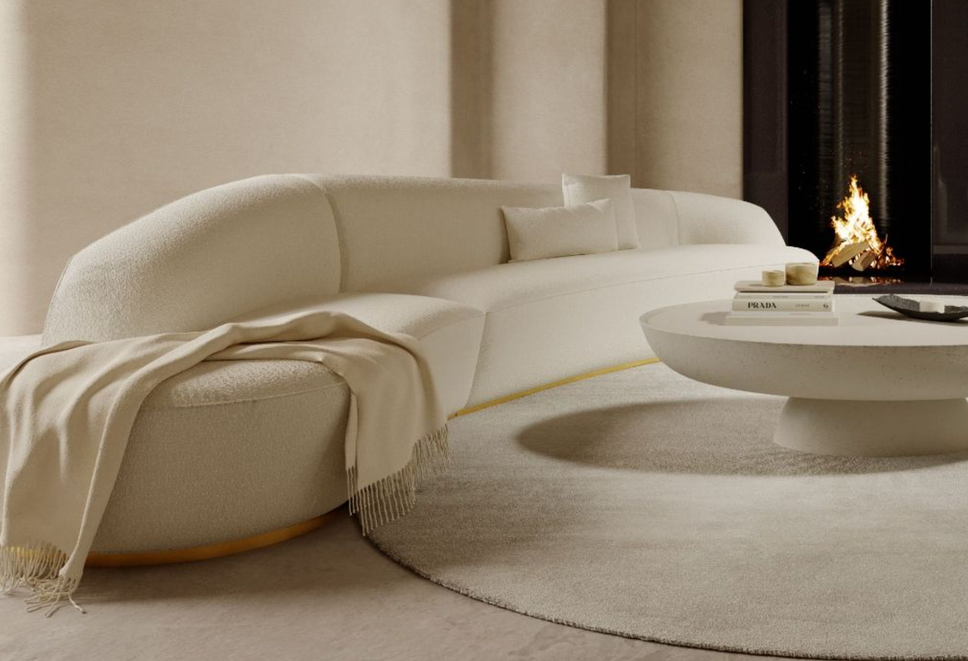 A stylish, minimalist living room features a curved cream-colored sofa with a beige throw blanket draped over one end. A round coffee table sits on a circular rug in front of the sofa. A modern fireplace with a visible flame adds warmth to the space.