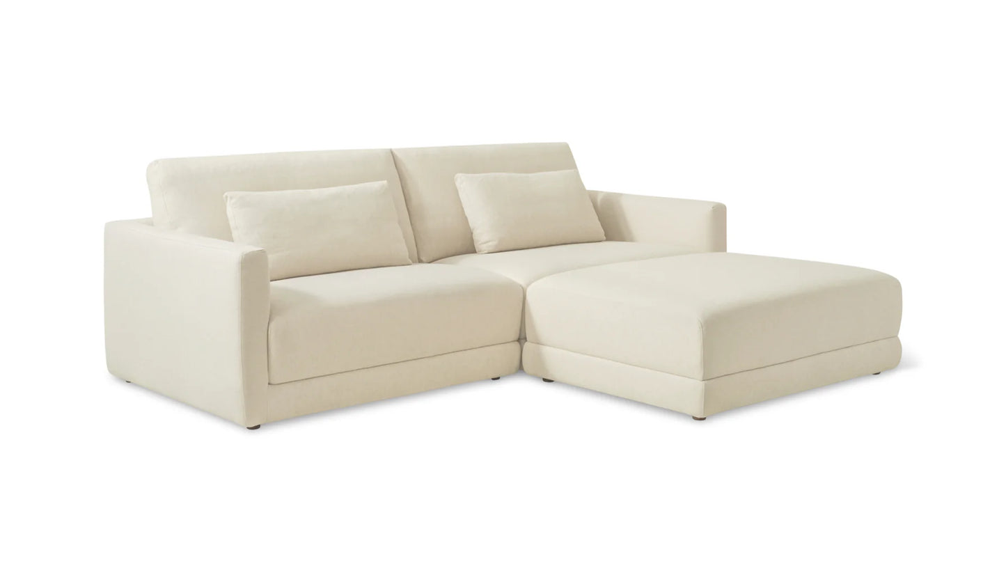 The Wind Down 4-Piece Modular Sectional is a cream-colored, L-shaped sofa featuring a chaise on the right side. It includes two backrest cushions and showcases a minimalistic, modern design with soft and smooth upholstery.