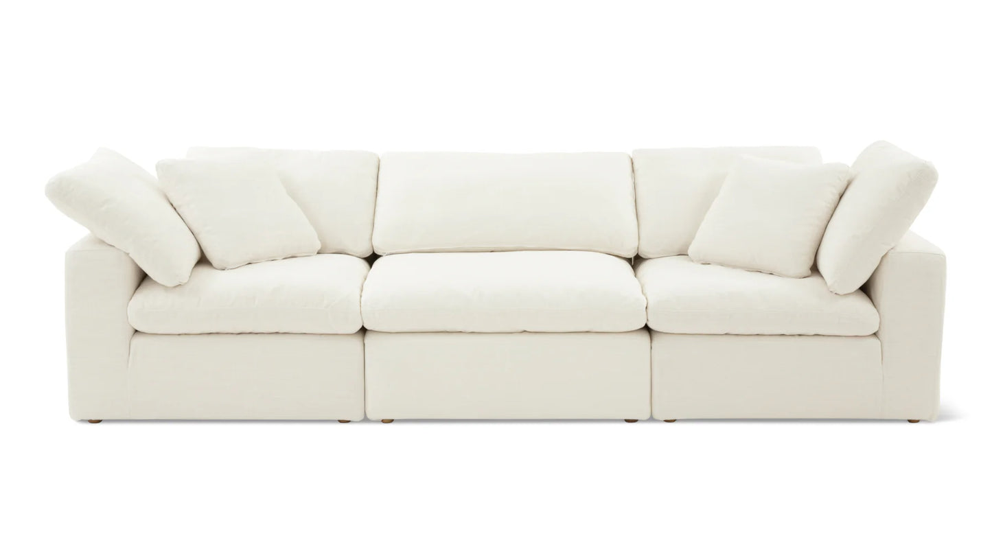 The Movie Night 3-Piece Modular Sofa is a plush, white sectional with three seats, adorned with five matching cushions. It showcases clean lines and a minimalist design, all set against a plain white background.