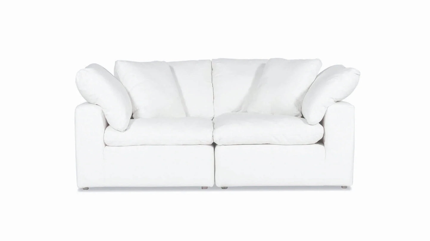 A Movie Night 3-Piece Modular Sofa in white, featuring plush cushions and a contemporary design, set against a plain white background. This cozy sofa offers seating for two and includes four large cushions for added comfort.