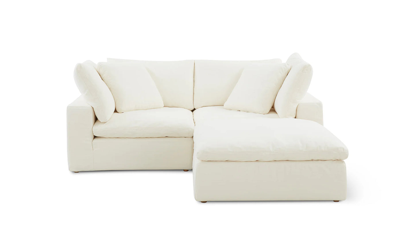 The Movie Night 3-Piece Modular Sofa, a white L-shaped sectional with plush cushions, is showcased against a plain white background. It boasts a right-side chaise section, offering a modern and minimalist appearance.