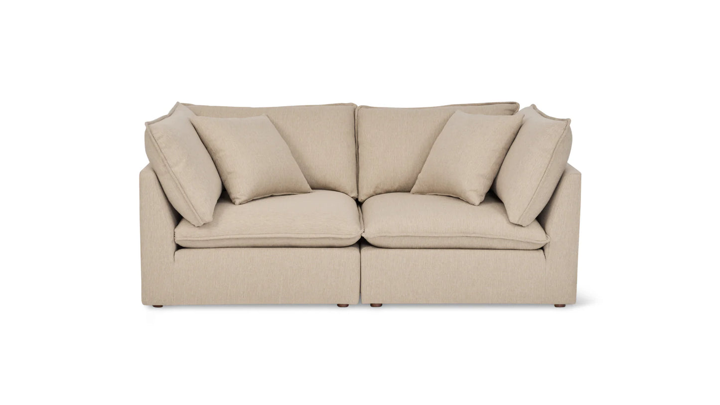 A Chill Time 4-Piece Modular Sectional, featuring a beige color with two large seat cushions and a backrest, is displayed against a white background, complete with four matching throw pillows. The sofa boasts a modern and minimalist design.