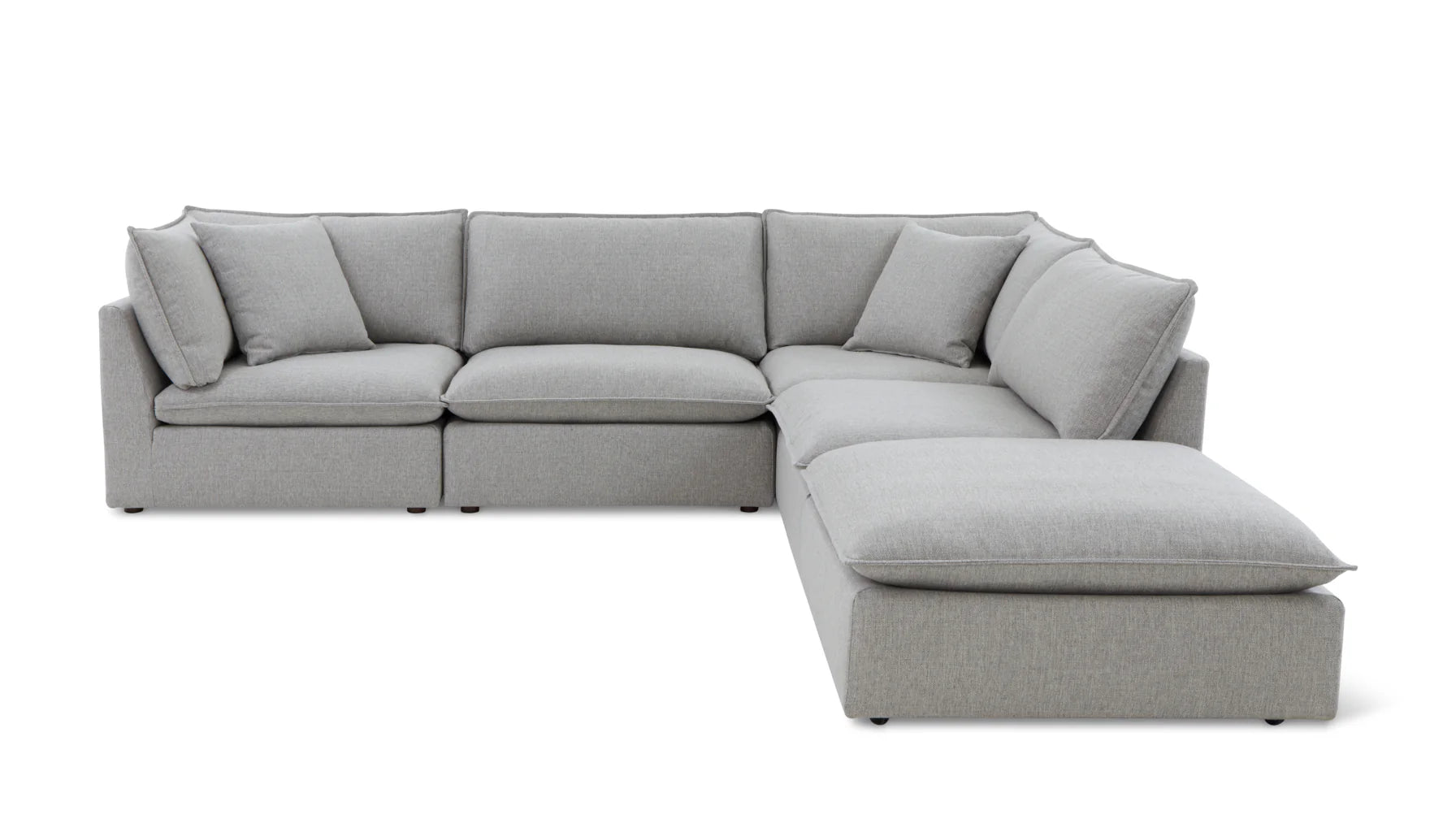 Introducing the Chill Time 4-Piece Modular Sectional, a spacious sectional sofa in light gray with a contemporary design. It features multiple cushions and a chaise lounge, forming a cozy L-shape. The sectional is set against a plain white background.