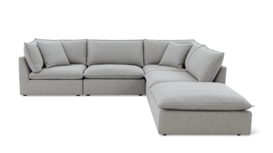 Introducing the Chill Time 4-Piece Modular Sectional, a spacious sectional sofa in light gray with a contemporary design. It features multiple cushions and a chaise lounge, forming a cozy L-shape. The sectional is set against a plain white background.