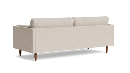 The Skinny Fat 85" Sofa Standard Depth is displayed from the back, showcasing its minimalist design with two plush cushions and wooden legs, all set against a plain black background.