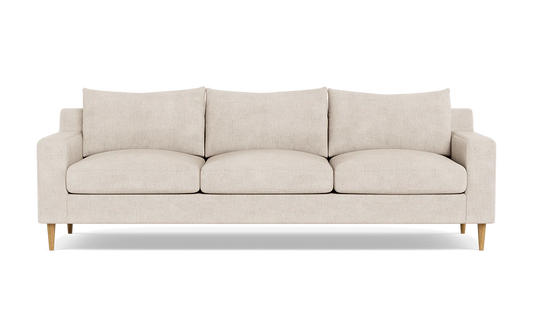 The Sloan Custom 3-Seat 95" Sofa features a beige color with a minimalist design, characterized by its clean lines, three cushions, and wooden legs, photographed against a plain black background.