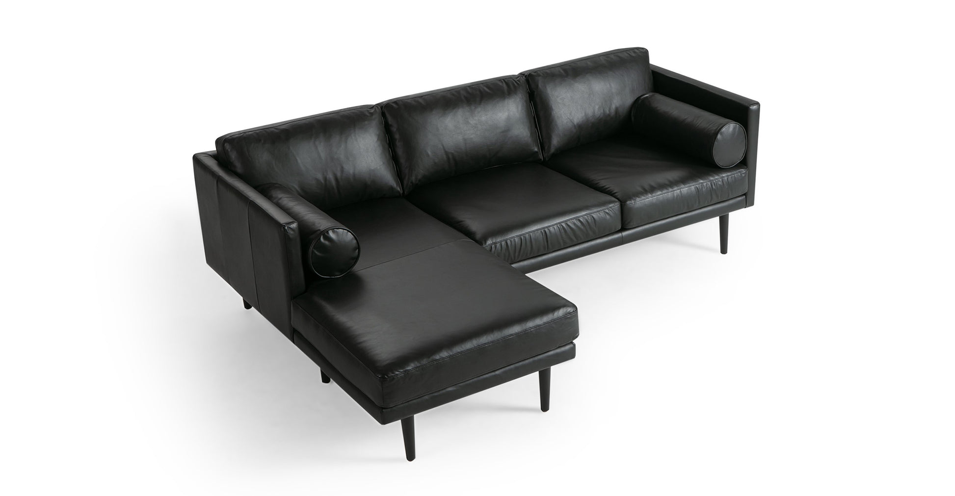 The Spectre 81" Leather Sofa Sectional Left in Napoli Grey is a sleek piece that includes a chaise lounge on the left side. It boasts slim armrests and black tapered legs, accompanied by two cylindrical bolster pillows, offering a modern and minimalist design.