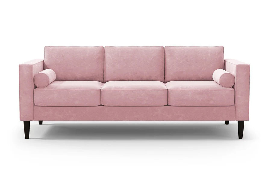 Introducing the Samson Sofa: a pink three-seater sofa featuring square arms and cylindrical bolster pillows. It includes three plush cushions and is supported by elegant dark wooden legs, all showcased against a plain white background.