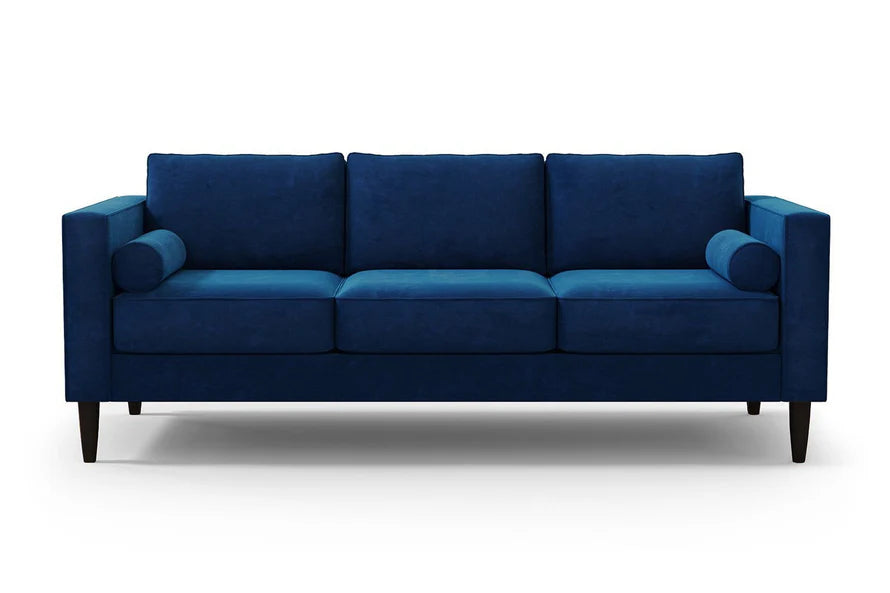 The Samson Sofa is a contemporary piece featuring a modern blue design with three seat cushions and two cylindrical armrest pillows. Its sleek, straight lines and dark wooden legs stand out beautifully against a plain white background.