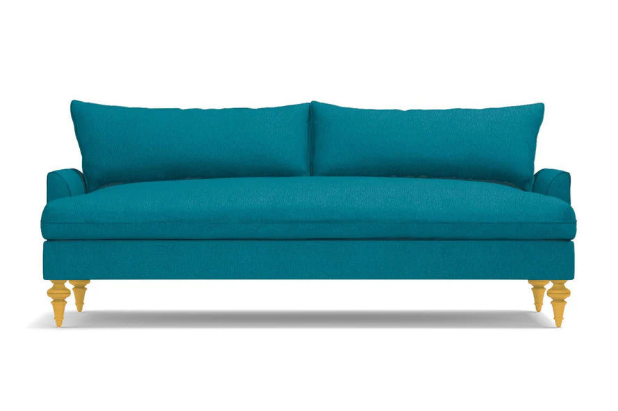 The Saxon Sofa is a modern and minimalist design, featuring a vivid teal color, two large back cushions, and four light wooden legs that stand out against a white background with sleek lines.