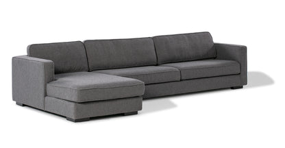 The Architect 133" Fabric Sofa Sectional Left in Blanc Boucle features a modern design with dark gray fabric, three back cushions, and a left-side chaise lounge. It is characterized by straight, clean lines and black legs, all set against a white background.