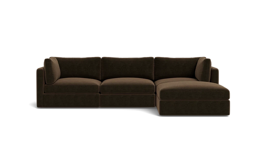 The Tatum Modular 3 Seat Chaise 106" Sectional is a dark brown piece featuring three seat cushions and a chaise lounge on the right. It boasts clean lines and a plush appearance, set against a plain black background.