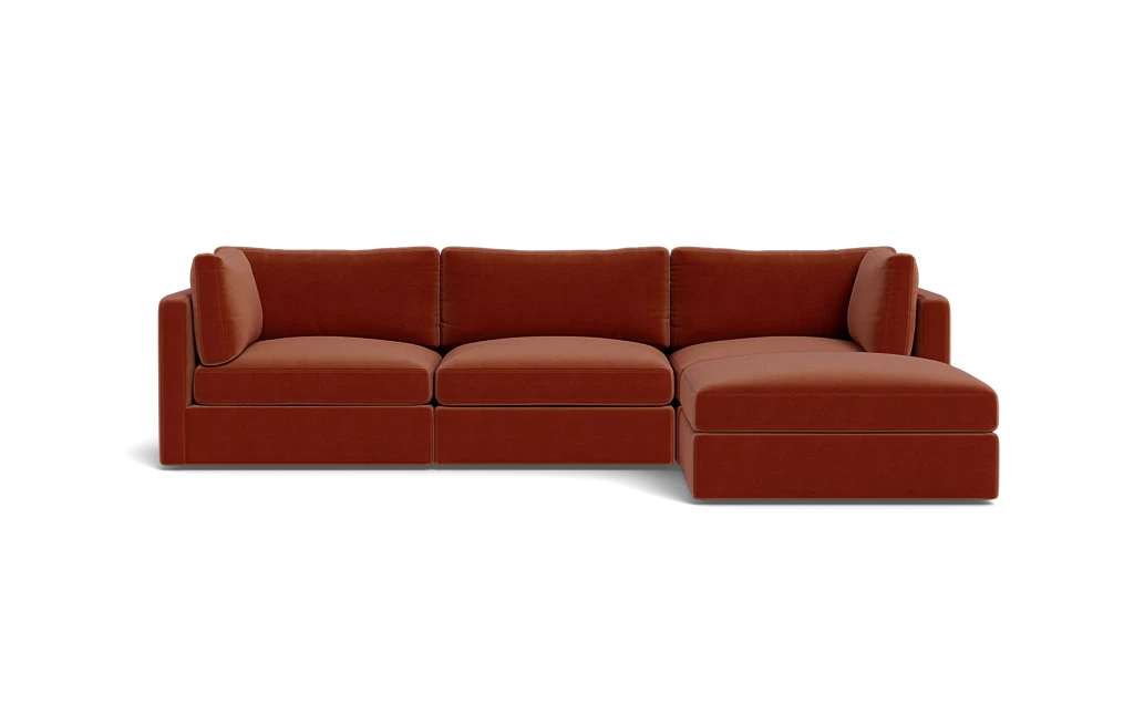 A contemporary Tatum Modular 3 Seat Chaise 106" Sectional showcasing clean lines, adorned with deep orange cushions, set against a simple black backdrop, and offering plush seating.