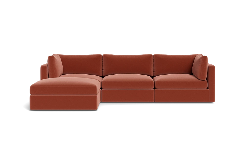 A sleek Tatum Modular 3 Seat Chaise Sectional in a rust hue, featuring a left-side chaise and showcased against a black backdrop. This sectional is designed with plush cushions and embodies a streamlined, minimalist aesthetic.