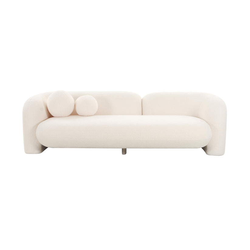 The Amelie Faux Fur Sofa is a minimalist piece in white, showcasing curved edges and equipped with two round cushions positioned on one side. It boasts a contemporary design with a low backrest and includes a short central leg for support.