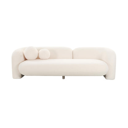 The Amelie Faux Fur Sofa is a minimalist piece in white, showcasing curved edges and equipped with two round cushions positioned on one side. It boasts a contemporary design with a low backrest and includes a short central leg for support.