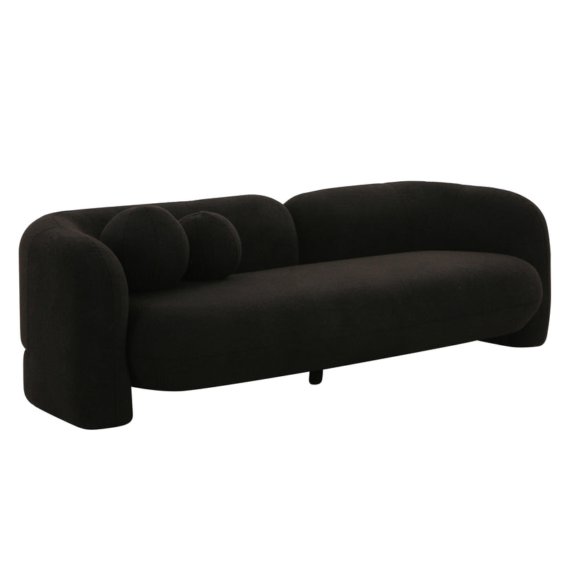 The Amelie Faux Fur Sofa boasts a modern, minimalist design with a sleek black finish. It features rounded edges and comes with two circular cushions, offering a smooth, plush texture that enhances its contemporary aesthetic.