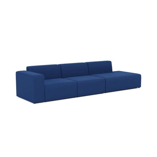 The Three-Seater Form Sectional is a modern sofa featuring sleek dark blue fabric upholstery. Its minimalist design boasts a block-style shape with clean lines and no visible legs, all set against a plain white backdrop.