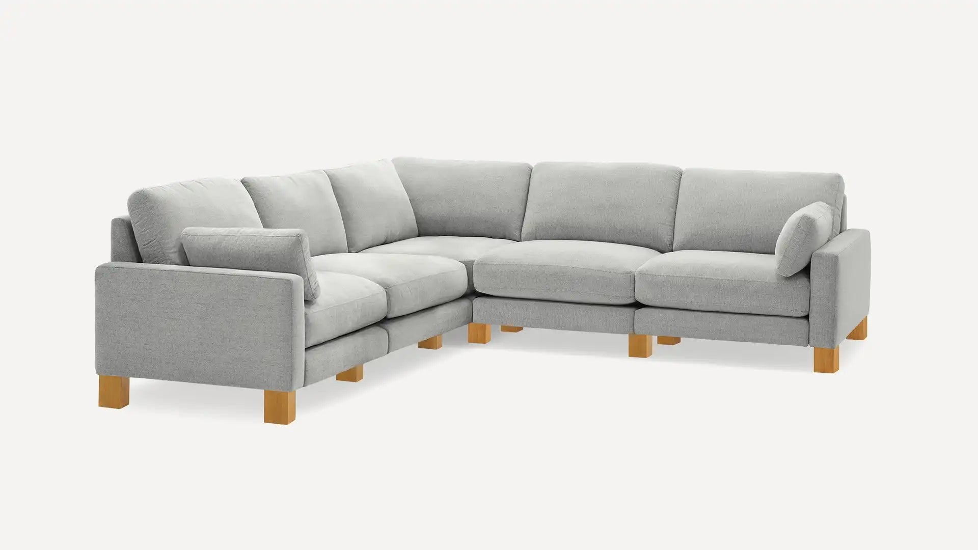 The Union Fabric Modular 5-Seat Sofa Sectional is presented with wooden legs in an L-shape arrangement, featuring thick cushions and a modern design perfect for a living room setting. The background is plain white.