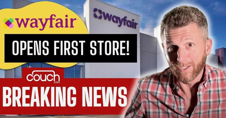 A man with short hair and a beard stands in front of a Wayfair store with a headline: "Wayfair Opens First Store!" and "Couch.com Breaking News" written below. The background shows a clear sky and part of the store's exterior.