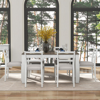 A dining room features a multifunctional, extendable wooden table set with a leaf and two drawers, surrounded by six cushioned chairs on a beige rug. A vase of yellow flowers sits at the center amid plates and glasses. Large windows display a view of trees in the background.