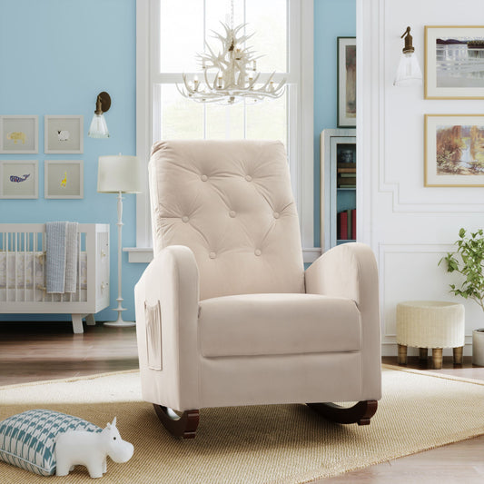 A cozy nursery room with a beige Baby Room High Back Rocking Chair, crib, and framed artwork on light blue walls. A plush toy and patterned cushion rest on a woven rug. Soft lighting from a chandelier and wall sconces enhances the serene atmosphere.