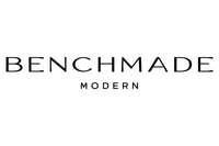 The image displays the logo of "Benchmade Modern," featuring the company name in a clean, sans-serif font. "BENCHMADE" is written in larger letters, while "MODERN" is written below it in smaller letters, all in black against a white background.