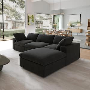 A contemporary living room showcasing a spacious black 142-inch square arm, 4-piece L-shaped sectional sofa made from corduroy polyester. The space is enhanced by expansive windows, a wooden floor, and minimalistic decor featuring paintings and a dining table in the background.