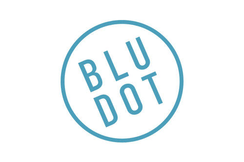 A simple logo featuring the words "BLU DOT" in uppercase blue letters, set at an angle within a blue circle against a white background.
