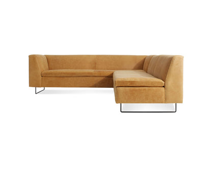 The Bonnie and Clyde Sectional Sofa is a modern L-shaped piece, crafted from tan leather with sleek black metal legs. It boasts a minimalist design and a comfortable backrest, showcased against a plain white background.