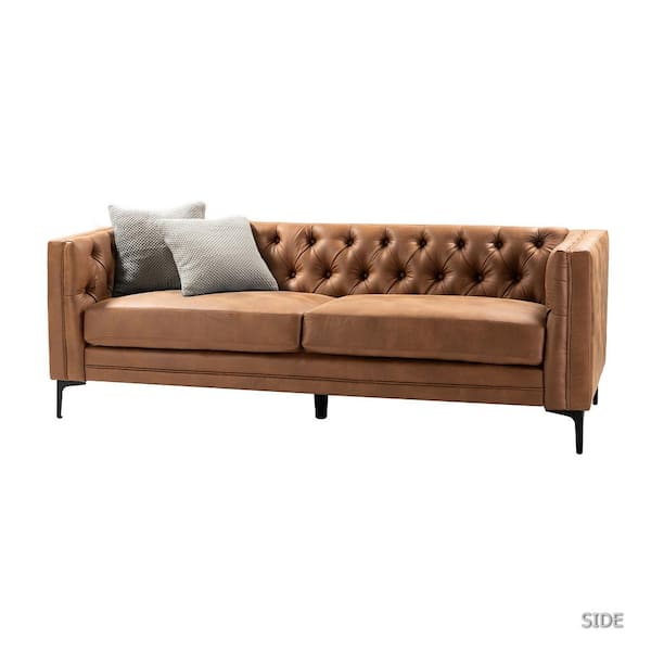 A camel faux leather button-tufted sofa with a contemporary design from JAYDEN CREATION is shown against a plain white background. It has square arms, black metal legs, and comes with two cushions: one gray and one patterned.