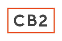 The image features the logo for CB2, with large, bold black letters "CB2" centered inside a rectangular red border on a white background.
