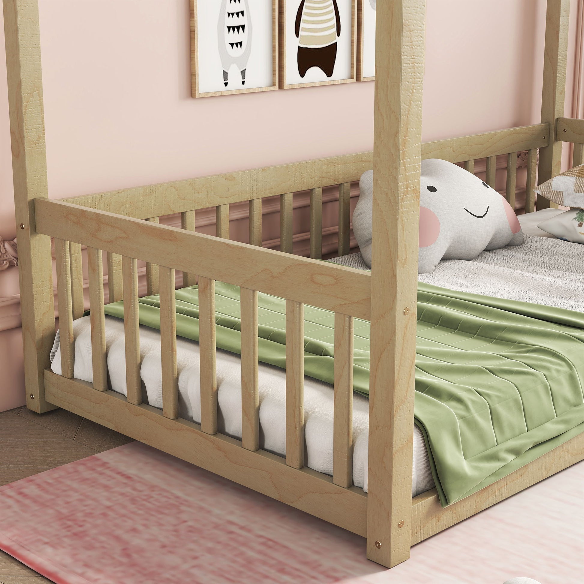 A Canopy Frame Floor Bed With Fence, Guardrails is shown, featuring a white mattress, green blanket, and smiling elephant pillow. The room has light pink walls and partial framed art above the bed.