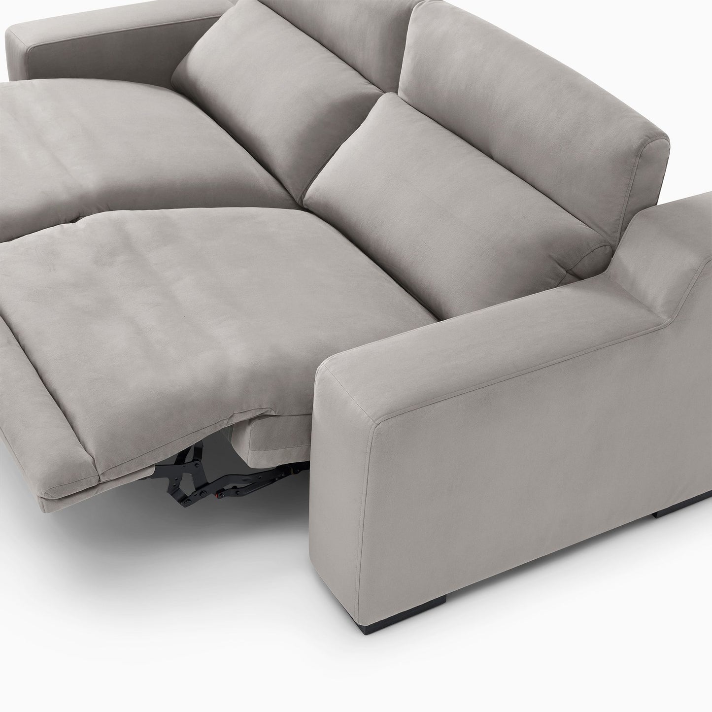 The Dalton Motion Sofa, in a light gray color with adjustable reclining seats, showcases a modern design. The image captures a partially extended footrest, highlighting its emphasis on comfort and functionality. This stylish sofa is set against a smooth, neutral floor.