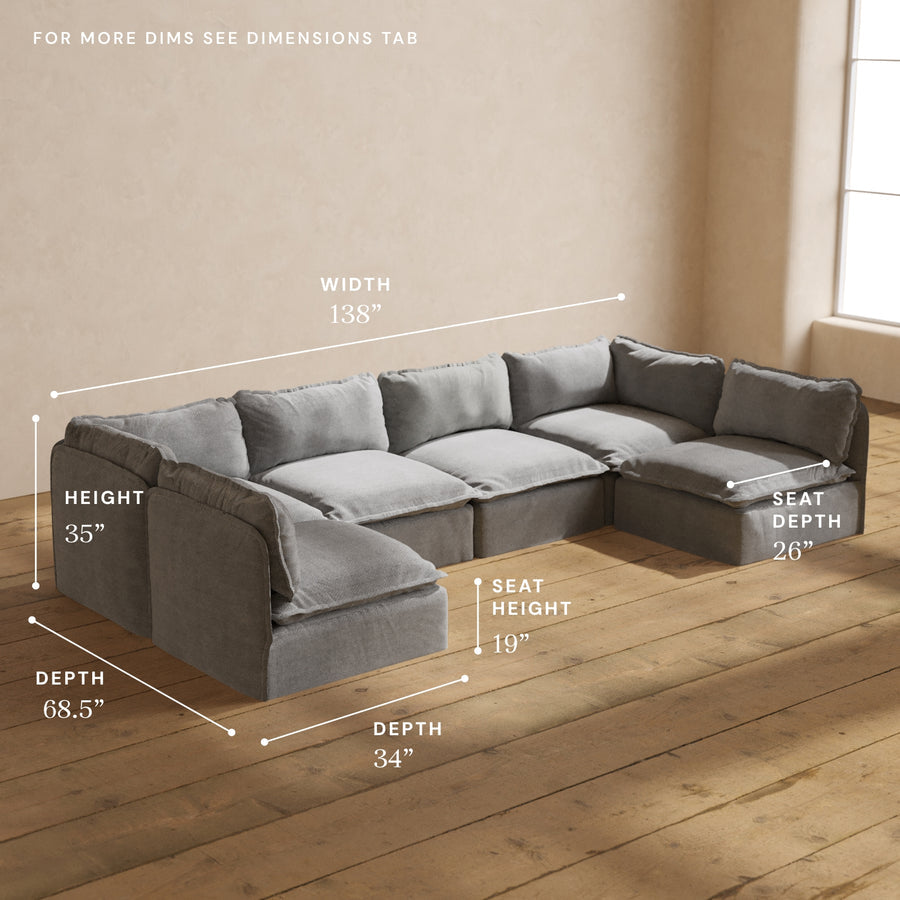 The Modular Performance 6-Seater Open-Ends U-Sectional Plush Weave Ash, showcased on a wooden floor, features dimensions labeled as width 138", height 35", depth 68.5", seat height 19", seat depth 26". It is elegantly positioned in a sunlit room with a beige wall backdrop.