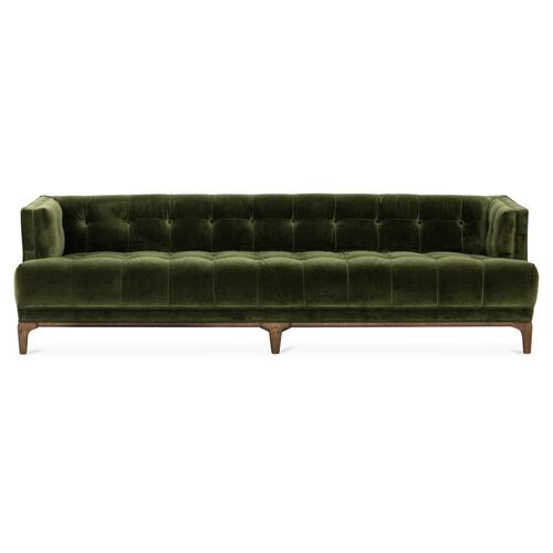 The Caledonia Sofa, upholstered in a rich sapphire olive velvet, features a tufted backrest and square armrests, all elegantly set on a wooden base.