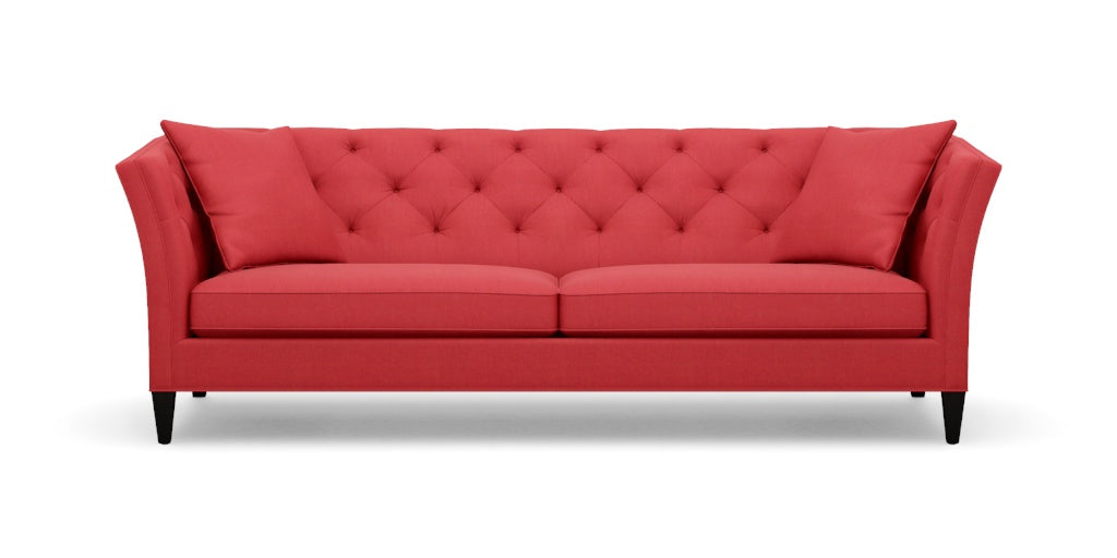 The Shelton 98" Sofa features a red color with a tufted backrest and two seat cushions, along with stylish flare arms. It rests on dark wooden legs and embodies a modern, elegant design.