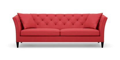 The Shelton 98" Sofa features a red color with a tufted backrest and two seat cushions, along with stylish flare arms. It rests on dark wooden legs and embodies a modern, elegant design.